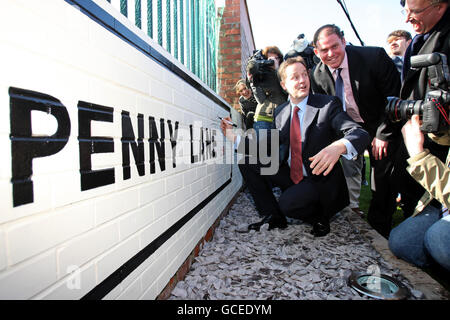 Nick Clegg, Vorsitzender der Liberaldemokratischen Partei, unterzeichnet bei einem Besuch des Penny Lane Development Trust in Liverpool eine neu gestrichene Wand neben dem PPC der Liberaldemokratischen Partei für den Liverpool Wavertree, Colin Eldridge. Stockfoto