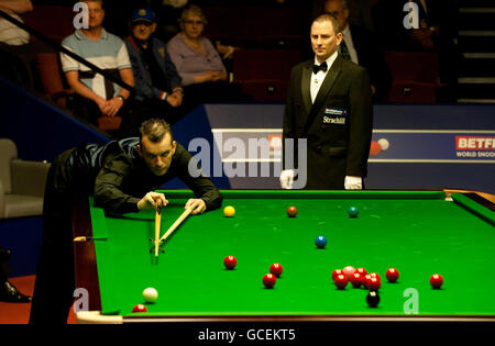 Mark Davis in Aktion gegen Ryan Day von Schiedsrichter Brendon Moore während der Snooker-Weltmeisterschaft Betfred.com im Crucible Theatre, Sheffield beobachtet. Stockfoto