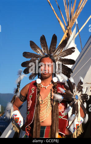 Gebürtige amerikanische Mann trägt zeremonielle Kleid vor Tipi, USA Stockfoto