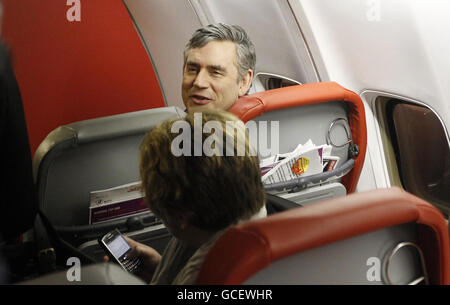 Premierminister Gordon Brown spricht mit einem Helfer, nachdem er am Flughafen Stansted in Essex landete, nachdem er von Schottland aus abgeflogen war. Stockfoto