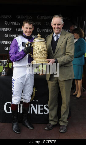 Der Jockey Richard Johnson (links) mit dem siegreichen Trainer Phillip Hobbs (rechts) erhält die Trophäe nach dem Sieg auf Planet of Sound im Punchestown Guinness Gold Cup während des Punchestown Festivals auf der Pferderennbahn in Punchestown, Dublin, Irland. Stockfoto