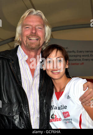 Sir Richard Branson hebt Natalie Imbruglia, die australische Sängerin und Schauspielerin, vor dem Virgin London Marathon im Excel Center im Osten Londons an. Stockfoto