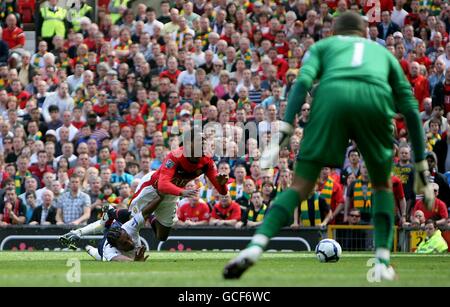 Patrice Evra von Manchester United (Mitte) wird von Benoit Assou-Ekotto von Tottenham Hotspur (links) innerhalb des Gebiets verschmutzt, was zu einer Strafe führt Stockfoto