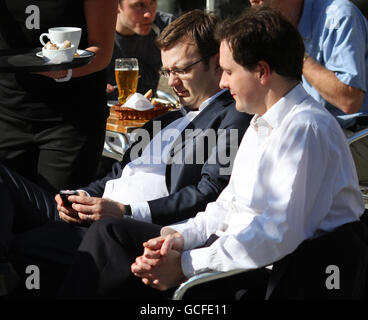 Andy Coulson, Direktor für Kommunikation und Planung der Konservativen Partei, mit dem Schattenkanzler George Osborne (rechts) in einem Open-Air-Café in Bristol vor der Debatte über die Wahlen zum Premierminister. Stockfoto