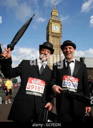 Läufer in ausgefallenen Kleidern passieren „Big Ben“ und die Houses of Parliament auf dem Parliament Square, während sie am Virgin London Marathon 2010 in London teilnehmen. Stockfoto