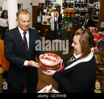 Der ehemalige Premierminister Tony Blair wird von Alex Haigh bei einem Besuch im Rams Head Inn in Denshaw zur Unterstützung von Phil Woolas, dem Labour-Kandidaten für Oldham East und Saddleworth, einen Kuchen geschenkt. Stockfoto