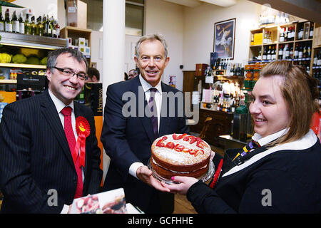 Der ehemalige Premierminister Tony Blair (Mitte) erhält einen Kuchen von Alex Haigh, beobachtet von Phil Woolas (links), dem Kandidaten der Labour-Partei für Oldham East und Saddleworth, während eines Besuchs im Rams Head Inn in Denshaw. Stockfoto