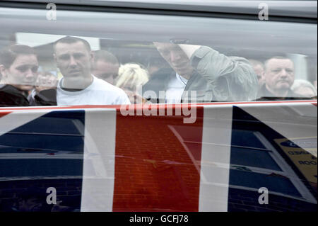 Paul Brayson, (Mitte rechts) ein Freund von Sapper Daryn Roy, 28, sieht als Leichenwagen mit den Särgen von Sapper Daryn Roy, Lance Corporal Barry Buxton und Corporal Harvey Holmes durch die Stadt Wootton Bassett nach ihrer Rückführung bei RAF Lyneham in Wiltshire. Stockfoto