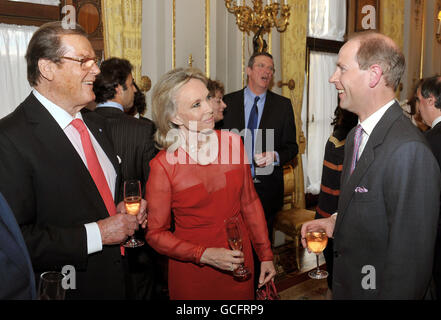 Der Earl of Wessex (rechts) spricht mit Sir Roger Moore und seiner Frau Kristina bei einem Getränkeempfang für die Wohltätigkeitsorganisation "Film Without Borders" im Buckingham Palace im Zentrum von London. Stockfoto