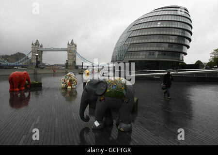 Ein Mann untersteht einem Regenschirm bei der Tower Bridge in London. Stockfoto