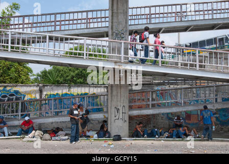 Zentralamerikanische Migranten warten unten einen Fußgängerweg für einen vorbeifahrenden northbound Zug zu hüpfen, auf ihrer Reise in die USA. Stockfoto