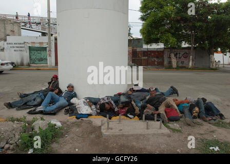 Eine Gruppe von zentralamerikanischen Migranten warten unter einer Autobahn Unterführung nördlich von Mexiko-Stadt für einen vorbeifahrenden northbound Zug zu hüpfen. Stockfoto