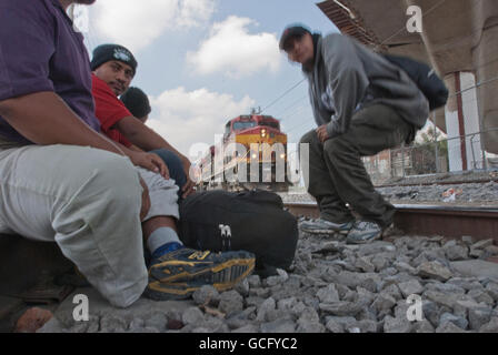 Zentralamerikanische Migranten warten auf den Bahngleisen vorbereiten auf einen beweglichen Güterzug Richtung Norden zu springen. Stockfoto