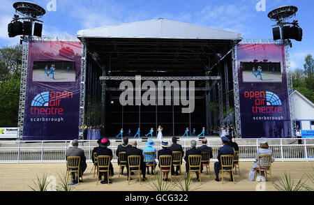 Queen Elizabeth II sieht sich eine Aufführung einer lokalen Theatergruppe in Scarborough, North Yorkshire, an, als sie das neu restaurierte Open Air Theatre in Northstead Manor Gardens, dem größten Freilufttheater Europas, offiziell eröffnete. Stockfoto