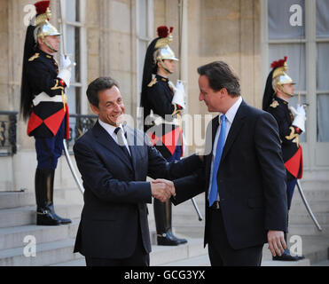 Der britische Premierminister David Cameron (rechts) wird vom französischen Präsidenten Nicolas Sarkozy im Elysees Palace in Paris, Frankreich, auf seinem ersten Ausflug auf die Weltbühne als Premierminister begrüßt. Stockfoto