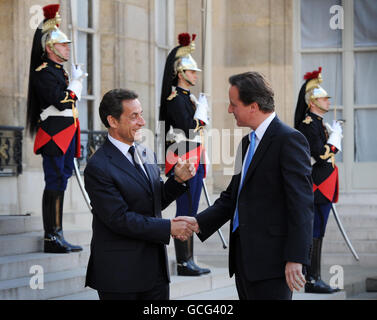 Der britische Premierminister David Cameron (rechts) wird vom französischen Präsidenten Nicolas Sarkozy im Elysees Palace in Paris, Frankreich, auf seinem ersten Ausflug auf die Weltbühne als Premierminister begrüßt. Stockfoto