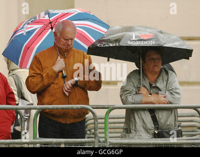 Zuschauer schützen sich vor dem Regen, um die Colonel's Review of the Trooping the Color Parade auf der Horseguards Parade, Westminster, im Zentrum von London zu beobachten. Stockfoto