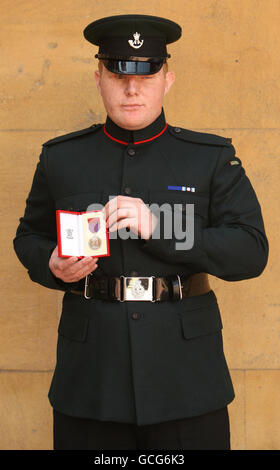 Rifleman Paul Jacobs besitzt die George-Medaille, die ihm für seine Tapferkeit in Afghanistan verliehen wurde, die ihm von der britischen Königin Elizabeth II. Bei einer Investiturzeremonie im Buckingham Palace, London, verliehen wurde. Stockfoto