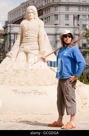 Der britische Sandbildhauer Paul Hoggard im Hyde Park, London, fügt der 12 Meter langen Sandskulptur des Prinzen von Persien einen letzten Schliff hinzu, bevor am Freitag, 21. Mai, das Videospiel Prince of Persia: The Forgotten Sands in Großbritannien erscheint. Stockfoto