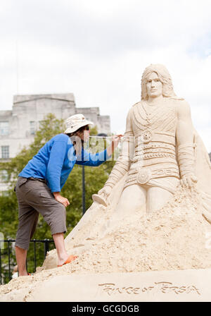 Der britische Sandbildhauer Paul Hoggard im Hyde Park, London, fügt der 12 Meter langen Sandskulptur des Prinzen von Persien einen letzten Schliff hinzu, bevor am Freitag, 21. Mai, das Videospiel Prince of Persia: The Forgotten Sands in Großbritannien erscheint. Stockfoto