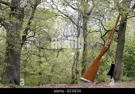 Die Künstlerin Cornelia Parker mit ihrer Arbeit "Landscape with Gun and Tree" eine 9 m hohe Stahlflinte, die an einer Buche angelehnt ist, eine der neuen Arbeiten, die heute offiziell auf Jupiter Artland in der Nähe von Edinburgh vorgestellt werden. Stockfoto