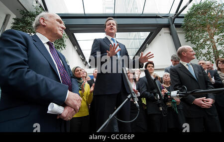 Der neue britische Wirtschaftsminister Vince Cable (links) und der Staatsminister für Universitäten und Wissenschaft, David Willetts (rechts), hören zu, wie Premierminister David Cameron bei einem offiziellen Besuch im Ministerium für Wirtschaft, Innovation und Qualifikationen im Zentrum von London spricht. Stockfoto