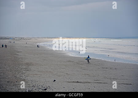 Ein einsamer Surfer auf eine lange Strecke von Muizenberg Beach an der False Bay, Cape Town South Africa Stockfoto