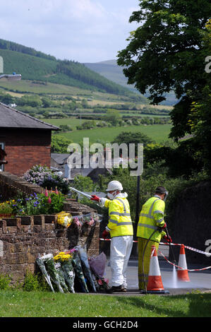 In Egremont werden Blumen-Tribute hinterlassen, während Arbeiter die Gegend säubern, nach dem Schussrausch von Derrick Bird in Cumbria, bei dem 12 Menschen ums Leben gekommen sind. Stockfoto