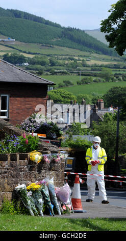 In Egremont werden Blumen-Tribute hinterlassen, während Arbeiter die Gegend säubern, nach dem Schussrausch von Derrick Bird in Cumbria, bei dem 12 Menschen ums Leben gekommen sind. Stockfoto