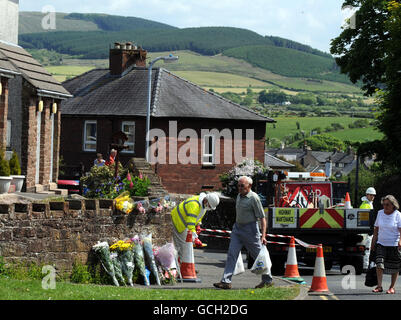 In Egremont werden Blumen-Tribute hinterlassen, während Arbeiter die Gegend säubern, nach dem Schussrausch von Derrick Bird in Cumbria, bei dem 12 Menschen ums Leben gekommen sind. Stockfoto