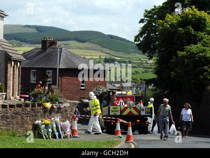 In Egremont werden Blumen-Tribute hinterlassen, während Arbeiter die Gegend säubern, nach dem Schussrausch von Derrick Bird in Cumbria, bei dem 12 Menschen ums Leben gekommen sind. Stockfoto