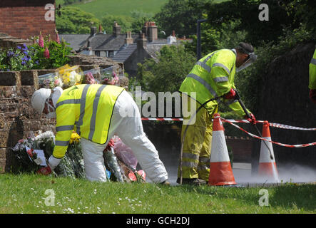 In Egremont werden Blumen-Tribute hinterlassen, während Arbeiter die Gegend säubern, nach dem Schussrausch von Derrick Bird in Cumbria, bei dem 12 Menschen ums Leben gekommen sind. Stockfoto