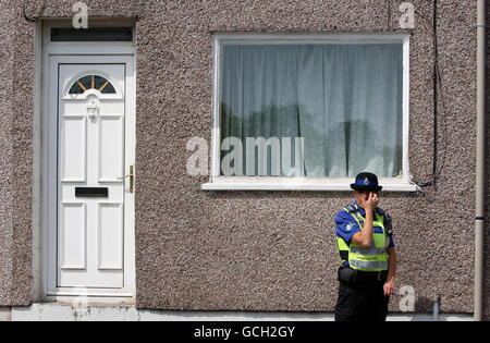 Ein Polizeibeamter steht vor dem Haus von Derrick Bird in Rowrah, während forensische Beamte weiterhin das Grundstück durchsuchen. Gestern wurden bei einem Schussanfalle in Cumbria 12 Menschen getötet. Stockfoto