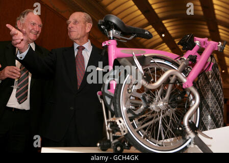 Der Duke of Edinburgh (rechts) bewundert den Gewinner des Prince Philip Designers' Prize, ein pinkfarbenes Brompton Klapprad, bei einem Empfang im Buckingham Palace, London. Stockfoto