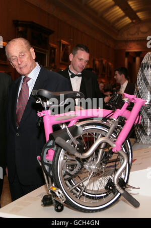 Der Duke of Edinburgh (links) bewundert den Gewinner des Prinz Philip Designers' Prize, ein pinkfarbenes Brompton Klapprad, bei einem Empfang im Buckingham Palace, London. Stockfoto