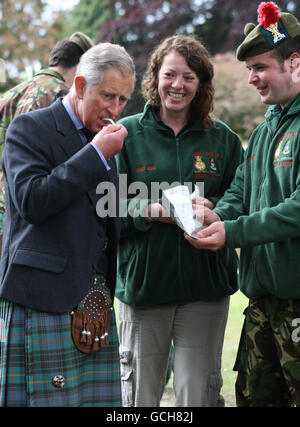 Der Prinz von Wales, der auch Royal Colonel des 3. Bataillons des Royal Regiment of Scotland ist, probiert während eines Besuchs im Balhousie Castle in Perth einige warme Speisen, die auf einem Feuer vom Army Cadet Force Outreach Project zubereitet werden. Eines von einer Reihe von offiziellen Engagements in Schottland heute. Stockfoto