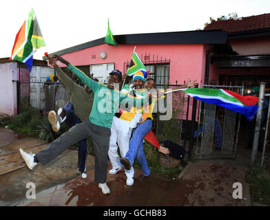 Südafrikanische Männer feiern vor einer Bar in Soweto, nachdem der Südafrikaner Siphiwe Tshabalala das Eröffnungstreffer der Weltmeisterschaft 2010 gegen Mexiko erzielte Stockfoto