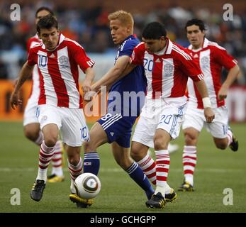 Fußball - FIFA Fußball-Weltmeisterschaft Südafrika 2010 - Runde 16 - Paraguay gegen Japan - Loftus Versfeld Stadium. Japans Keisuke Honda (Mitte) kämpft mit Edgar Benitez (links) und Nestor Ortigoza (rechts) um den Ball Stockfoto