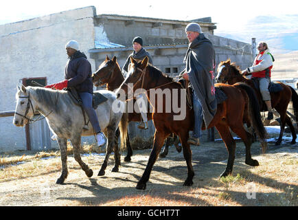 Prinz William (Mitte) und Prinz Harry (zweite rechts) kleideten sich zu Pferd in traditionellen Stammesdecken während eines Besuchs im Semongkong Kinderzentrum in Lesotho, wo sie verwaiste Kinder trafen. Stockfoto