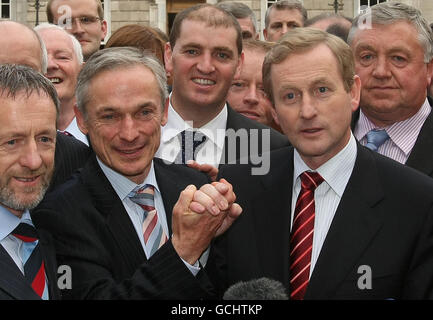 Fine Gael Leader Enda Kenny (Mitte rechts) schüttelt Richard Brutons (Mitte links) Hand auf dem Sockel des Leinster House, nachdem er bei einem entscheidenden parlamentarischen Parteitreffen für die Führung der Partei die Wahl gewonnen hat. Stockfoto