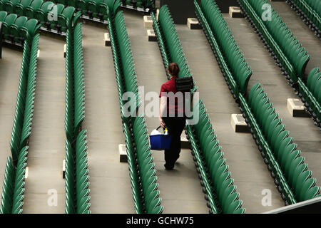 Das Bodenpersonal bereitet den Sitzbereich auf dem Center Court während eines Trainingstages für die Wimbledon Championships 2010 im All England Lawn Tennis Club, Wimbledon, vor. Stockfoto