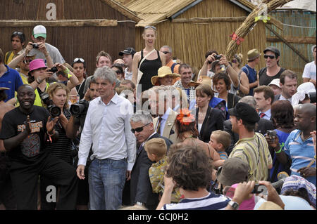 Der Prinz von Wales (Mitte) und Greenpeace-Geschäftsführer John Sauven beobachten einige afrikanische Tänzer auf dem Greenpeace-Feld während seines Besuchs beim Glastonbury Festival 2010 anlässlich des 40. Jahrestages der Veranstaltung auf der Worthy Farm, Pilton in Somerset. Stockfoto