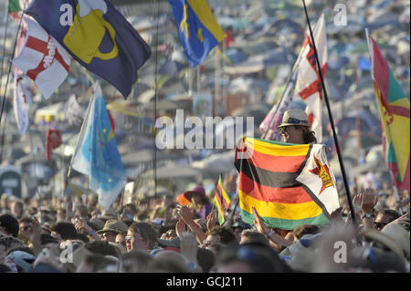 Ein Nachtschwärmer in der Menge, der Shakira gestern auf der Pyramid Stage beobachtet, fliegt am zweiten Tag der Musik beim Glastonbury Festival auf der Worthy Farm, Somerset, mit einer Flagge. Stockfoto