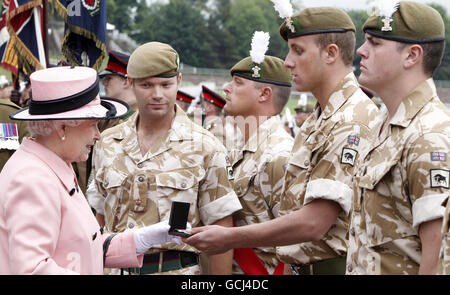 Die britische Königin Elizabeth II. Überreicht Soldaten des 1. Bataillons Royal Welsh während des Drumhead-Dienstes von Thanksgiving Kampagnenmedaillen, um ihre Rückkehr von Operationen in Afghanistan auf der Rennbahn Chester in Chester zu feiern. Stockfoto