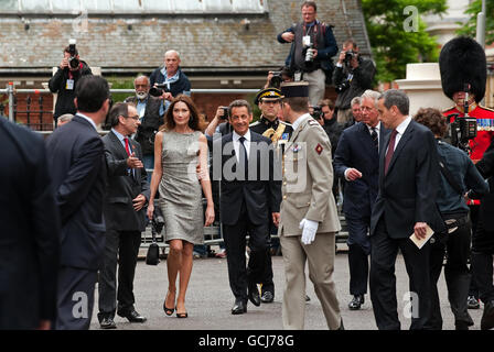 Der französische Präsident Nicolas Sarkozy (Mitte) und seine Frau Carla Bruni-Sarkozy (Mitte links) kommen an, um Fotos des französischen Präsidenten Charles De Gaulle während eines Besuchs im ehemaligen Hauptquartier der Freien Franzosen in Carlton Gardens im Zentrum von London zu sehen. Stockfoto