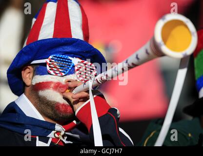 Fußball - FIFA Fußball-Weltmeisterschaft Südafrika 2010 - Gruppe C - Slowenien - USA - Ellis Park. Ein USA-Fan bläst vor dem Anpfiff eine Vuvuzela in die Tribüne Stockfoto