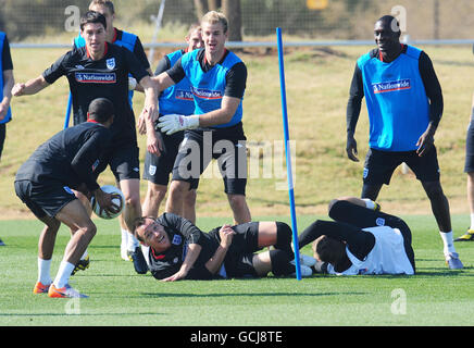 Der englische John Terry (Mitte, Boden) mit den Teamkollegen Gareth Barry (links), Joe Hart und Emile Heskey (rechts) während einer Trainingseinheit im Royal Bafokeng Sports Complex, Rustenburg, Südafrika. Stockfoto