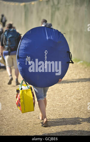 Eine Frau trägt ein Pop-up-Zelt, als sie das Glastonbury-Festivalgelände auf der Worthy Farm in Somerset verlässt, als es dem Ende zugeht. DRÜCKEN SIE VERBANDSFOTO. Bilddatum: Montag, 28. Juni 2010. Bildnachweis sollte lauten: Ben Birchall/PA Wire Stockfoto