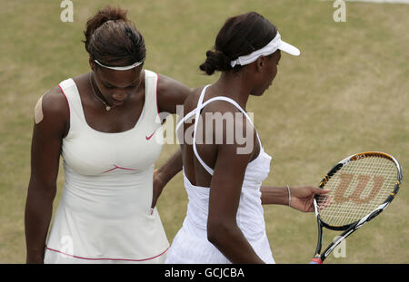 Die USA Venus (links) und Serena Williams stehen während ihrer Niederlage gegen die russische Vera Zvonareva und Elena Vesnina am 9. Tag der Wimbledon Championships 2010 im All England Lawn Tennis Club, Wimbledon, niedergeschlagen. Stockfoto