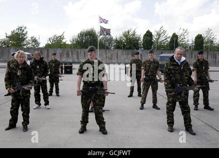 Rick Parfitt (links) und Francis Rossi (rechts) von Status Quo nehmen sich eine Auszeit, um eine Armeeübung zu machen, während sie das Video zu ihrer neuen Re-Release ihres Klassikers in The Army Now mit den 4 Riffeln in ihren Kiwi Barracks in Bulford, Wiltshire, aufnehmen. Stockfoto